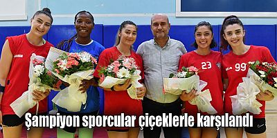 Şampiyon sporcular çiçeklerle karşılandı